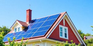 Solar panels on a Victorian house under a blue sky.