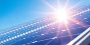 Solar panels gleaming in sunlight against a blue sky.