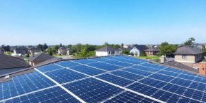Rooftop solar panels against a suburban backdrop.