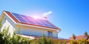 Home with solar panels under a clear blue sky.