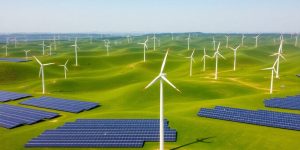 Wind turbines and solar panels in a green landscape.